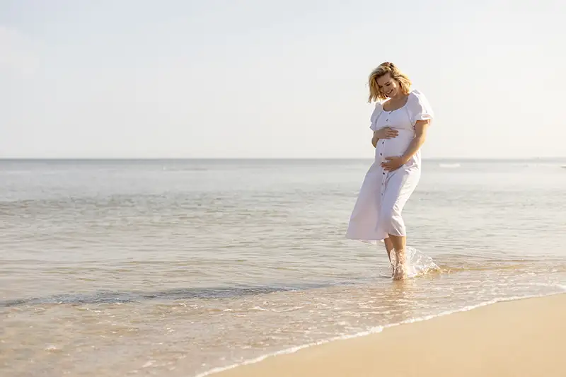 beautiful-pregnant-woman-in-white-dress-walking