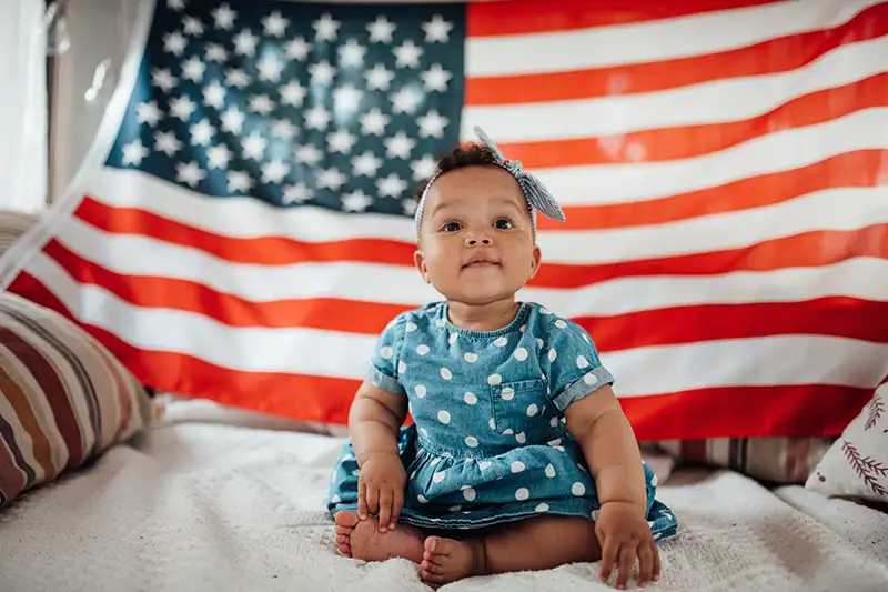 cute-baby-born-after-ivf-in-the-usa-sitting-in-front-of-american-flag